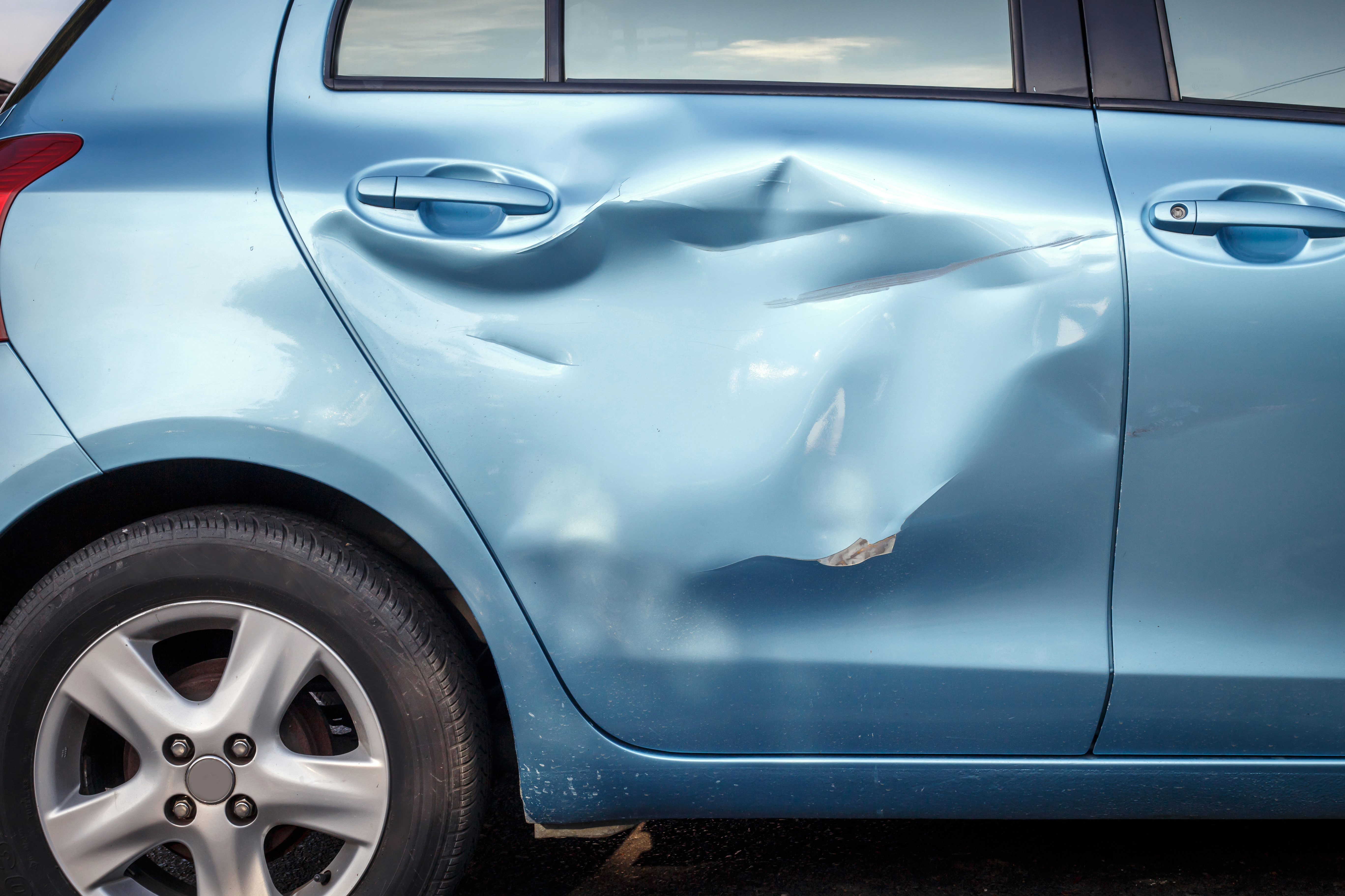 бочни поглед на плави аутомобил са оштећењем удеса преко десне стране